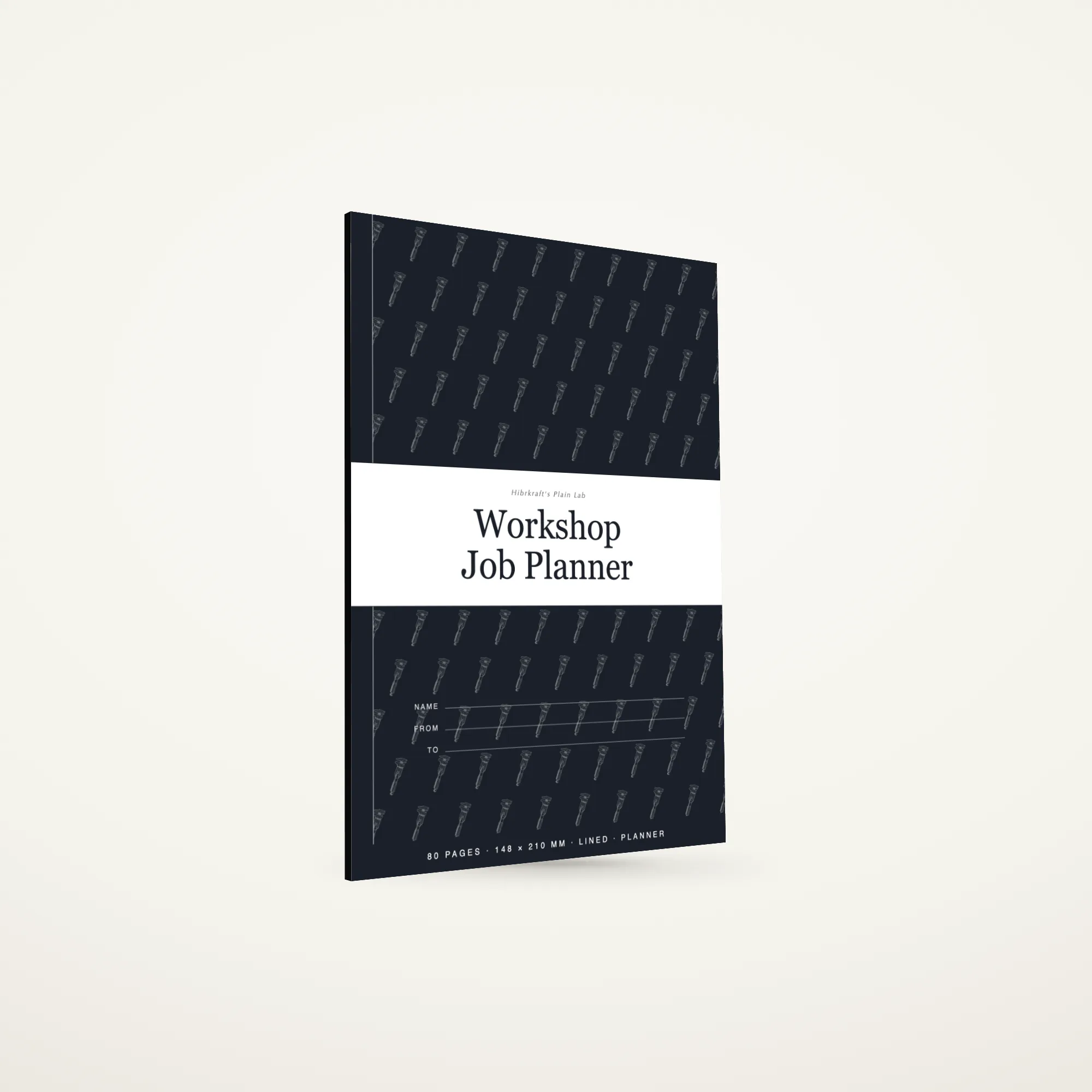 Workshop Job Planner A5 berdiri tertutup di atas permukaan polos, sampul berpita melintang di sepertiga bawahnya dengan judul dicetak terbalik, tebal sekitar lima milimeter.